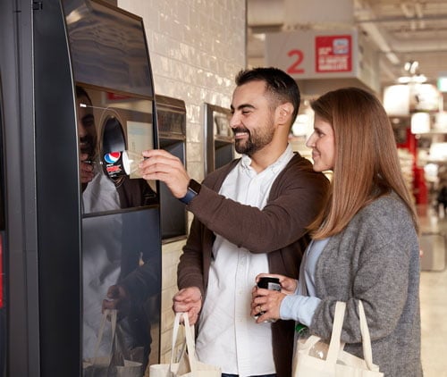 personas usando una máquina de vending inverso