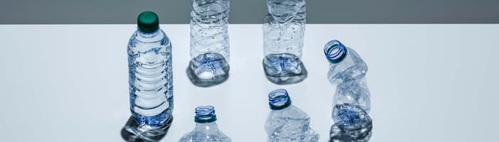 Un círculo de botellas de plástico en varias etapas del proceso de trituración