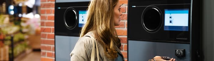 Woman using TOMRA T9 reverse vending machine