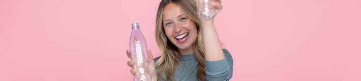 Chica con fondo rosa y botellas de PET
