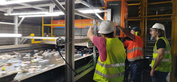 Homens trabalhando em uma máquina de triagem de resíduos com IA da TOMRA