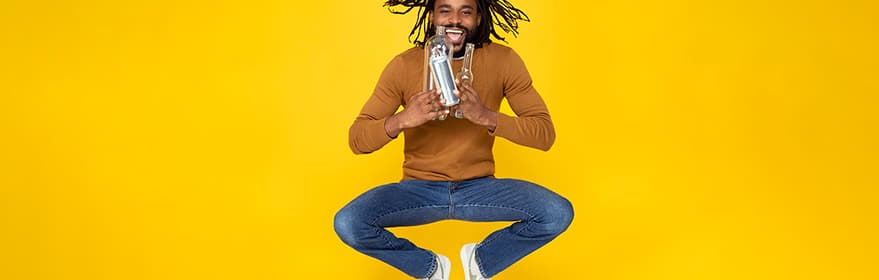 Happy guy jumping and holding PET bottles
