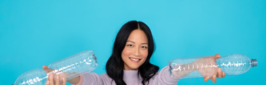 Asiatisk flicka som håller PET-flaskor