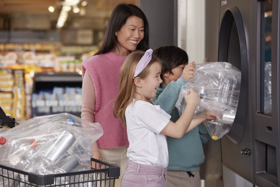 Imagen de una familia devolviendo envases a una máquina de vending inverso