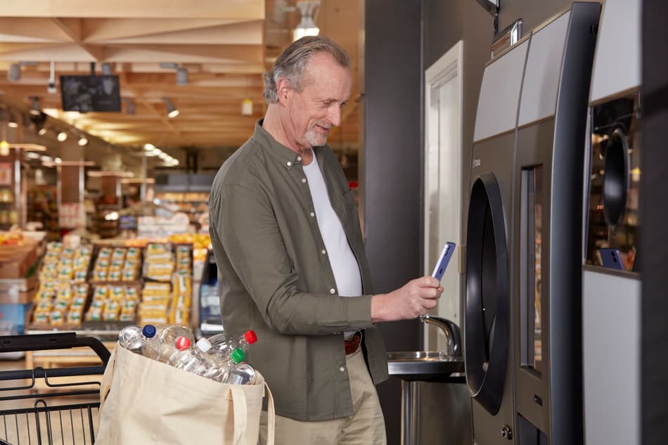 hombre escaneando móvil en máquina de vending inverso