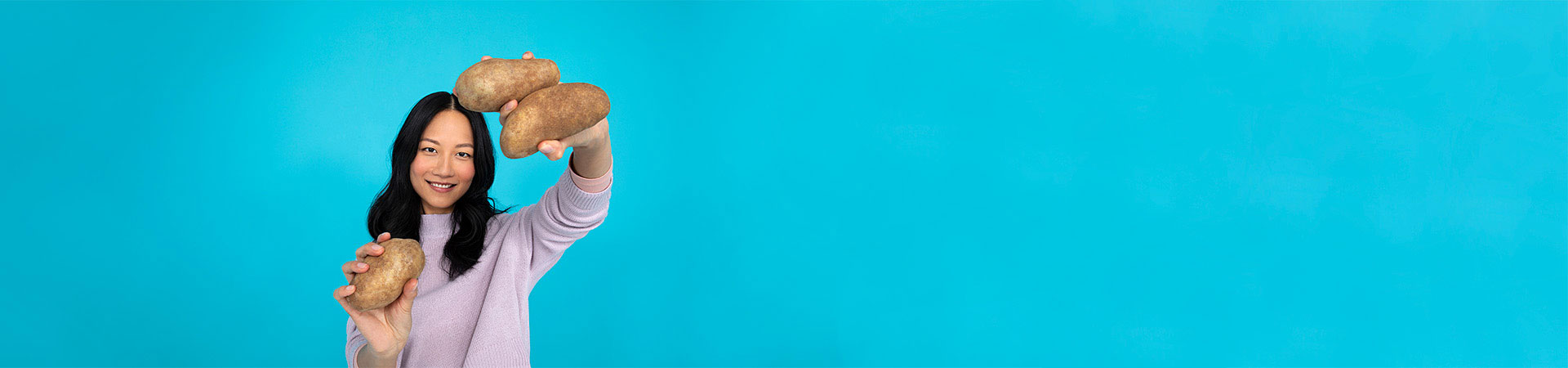 Girl holding up sorted large potatoes
