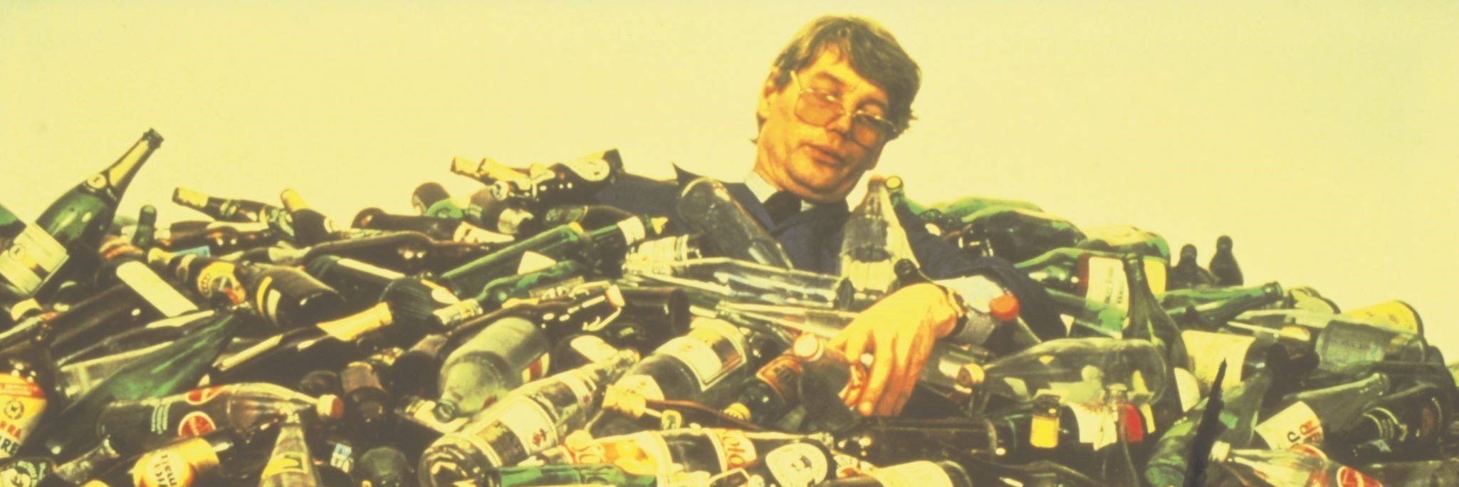 Man drowning in pile of bottles