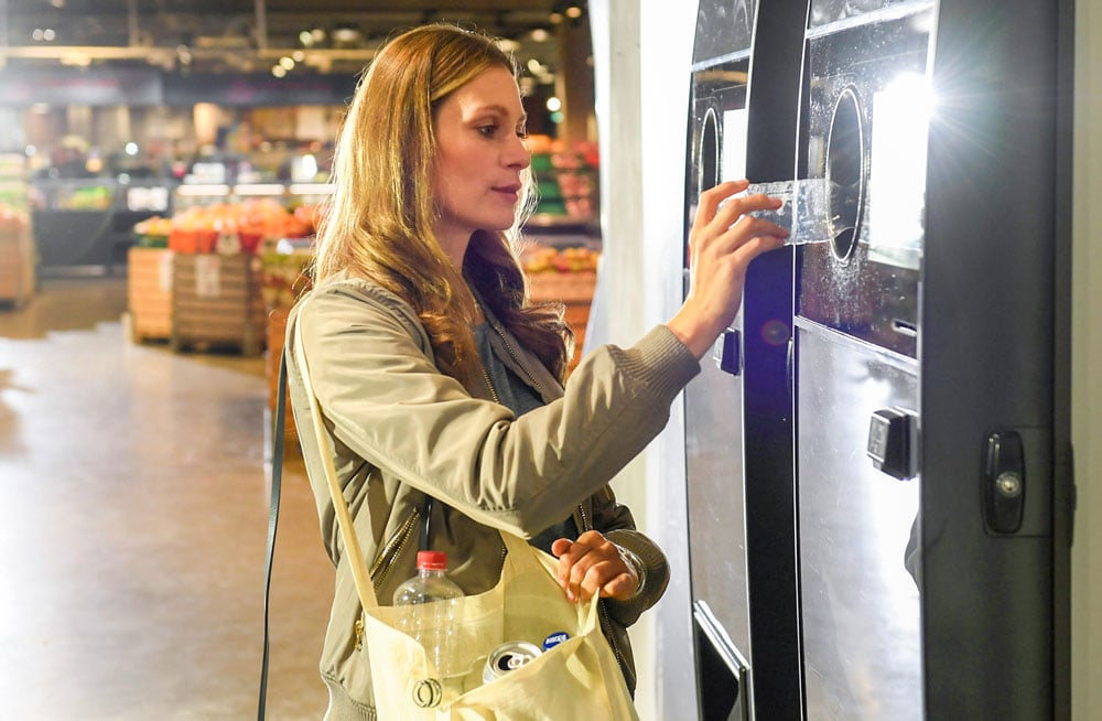image of a lady and a reverse vending machine