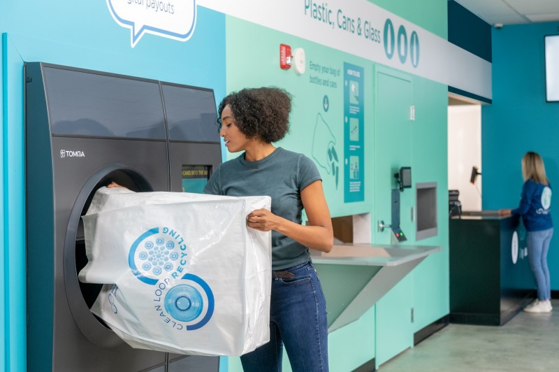 woman feeding bottles into a reverse vending machine