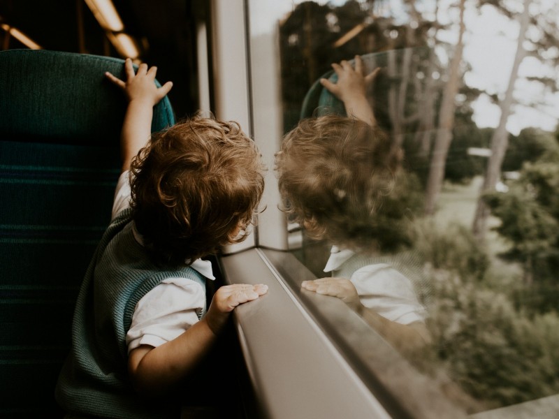 Bild eines Jungen, der aus dem Fenster schaut