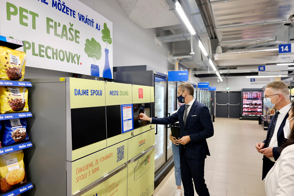 image of a man putting a bottle in a reverse vending machine