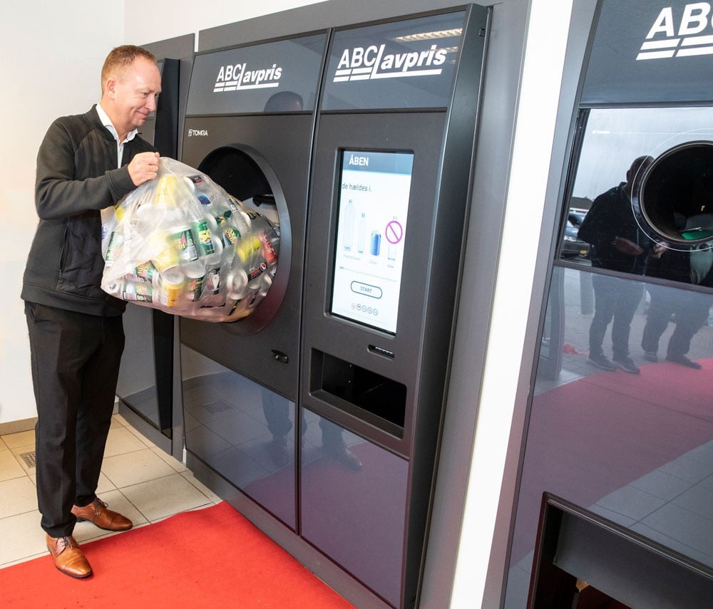 image of a man putting bottles into the reverse vending machine
