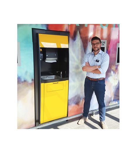 image of a man standing beside a wash  & waste machine