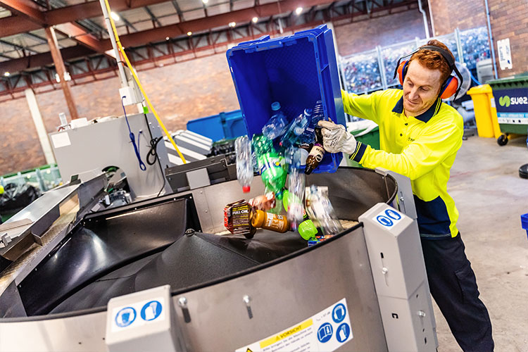 Men pouring containers into a Australian Expert line system