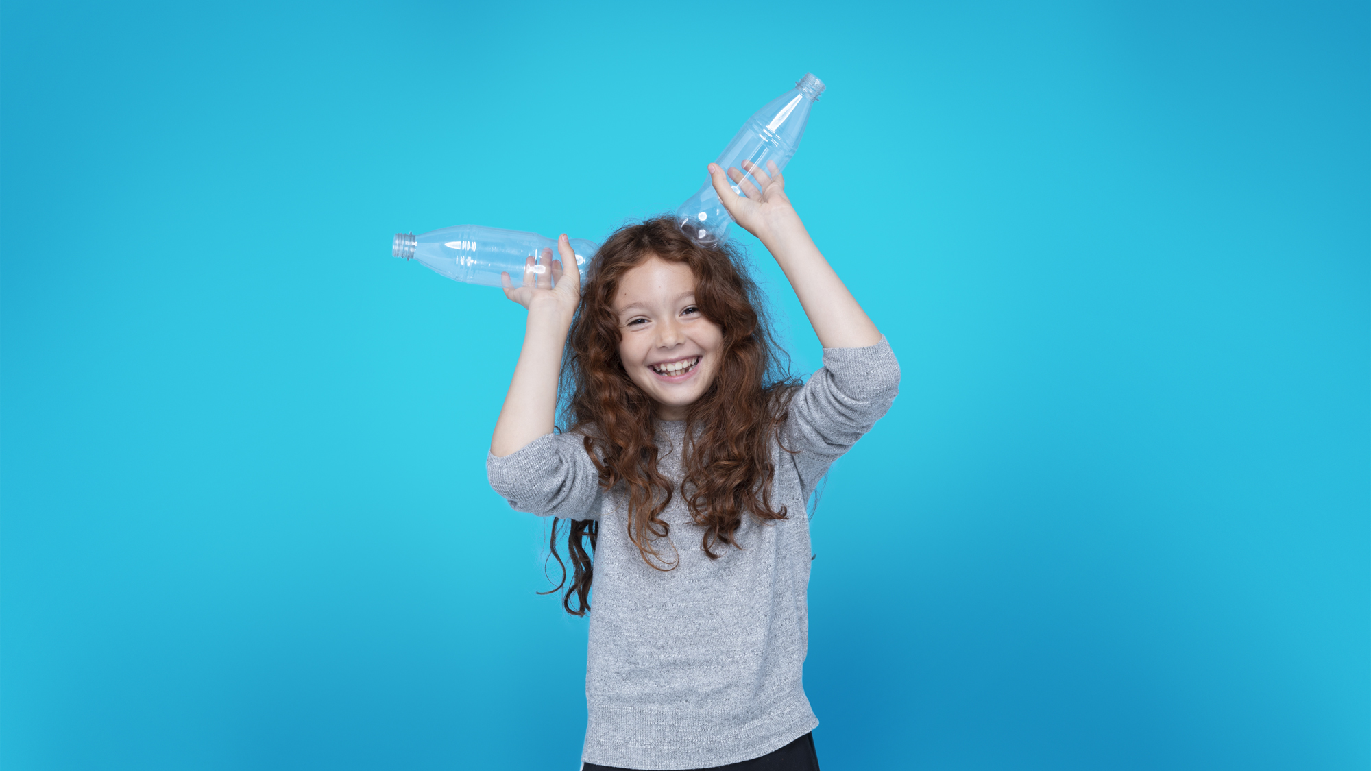 Girl in blue background with 2 bottles
