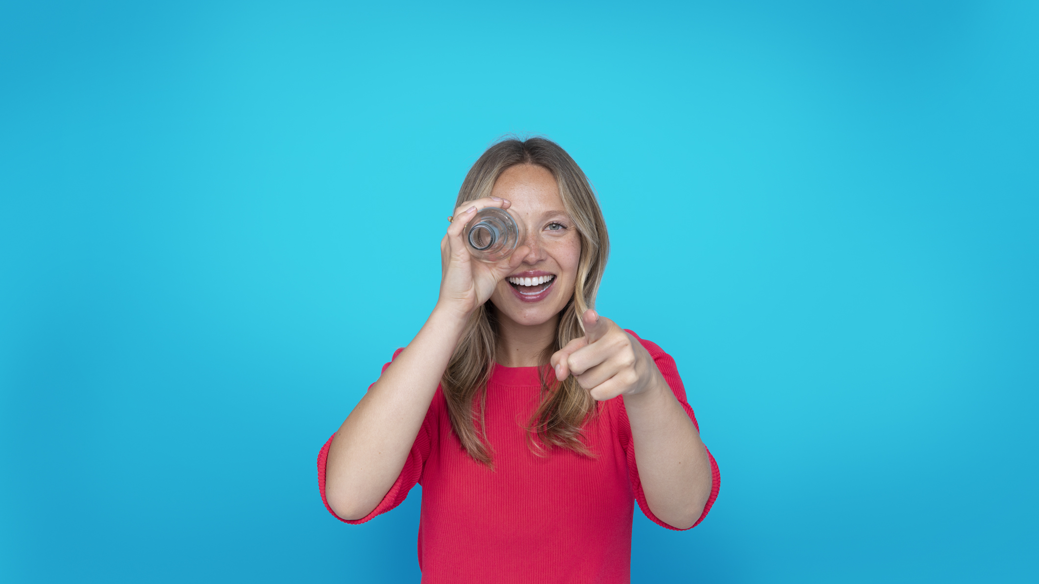 Blonde girl pink bckg pointing