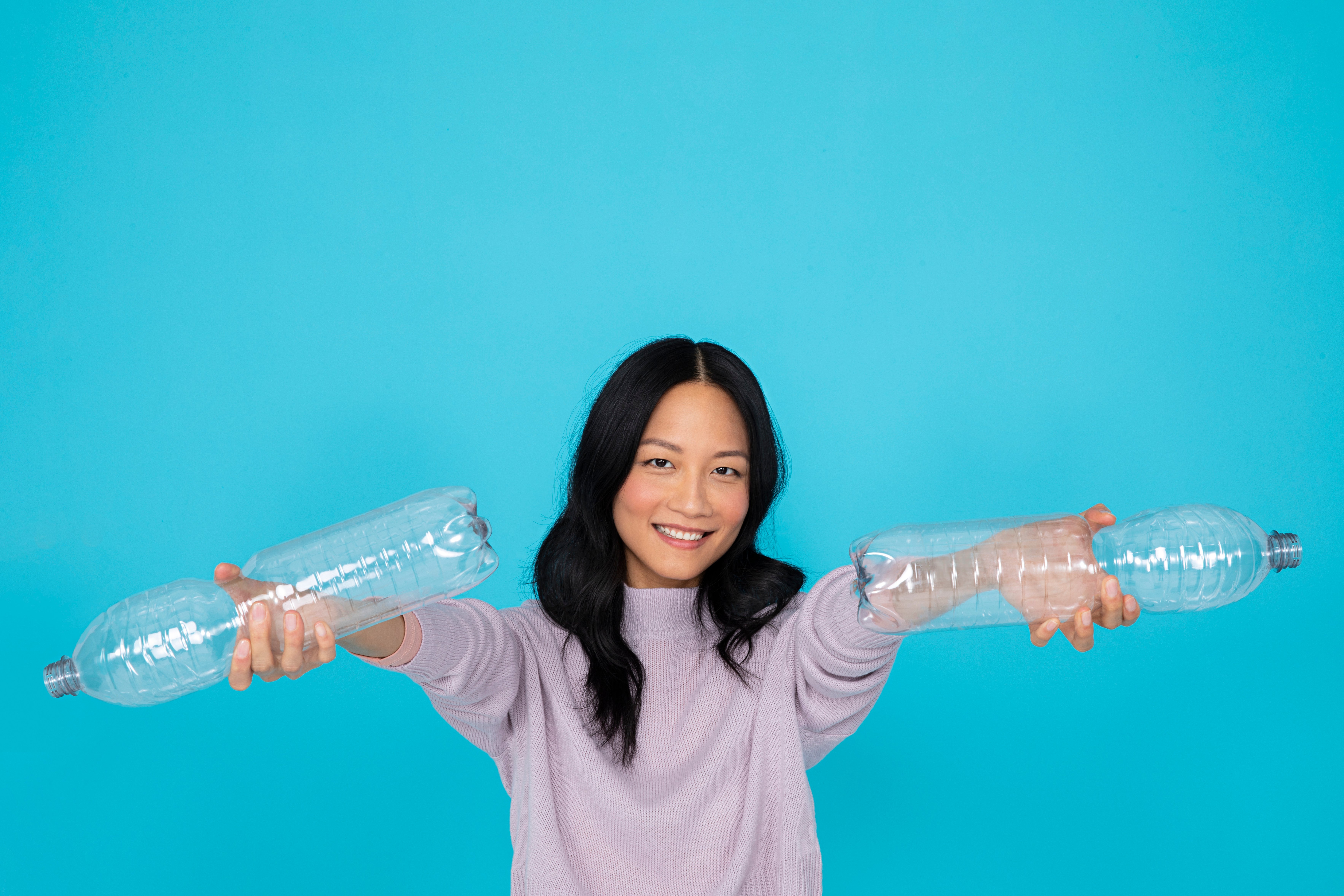 Asiatisches Mädchen hält PET-Flaschen