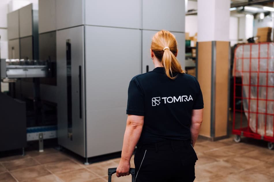 TOMRA employee in backgroom with TOMRA machine