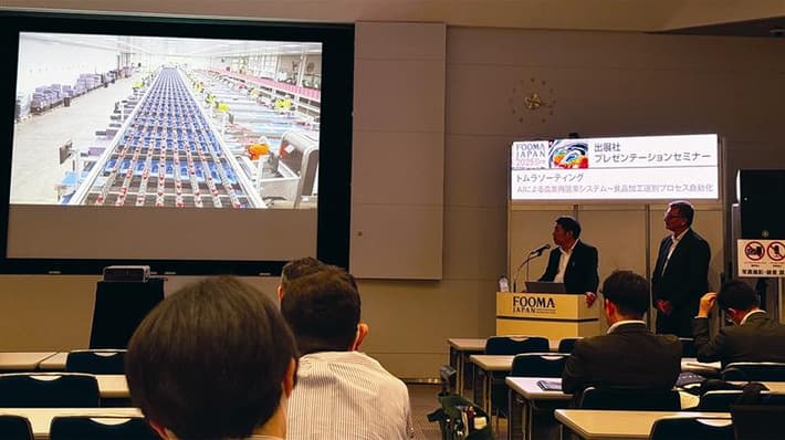An image of delegates at the FOOMA seminar in Tokyo with a presentation screen
