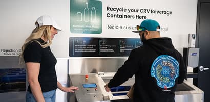 Man and woman using TOMRA Expert Line Reverse Vending Machine