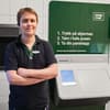 Store staff in front of Tomra R2 reverse vending machine