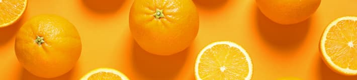 An image of oranges both whole and cut in half laying flat on an orange background