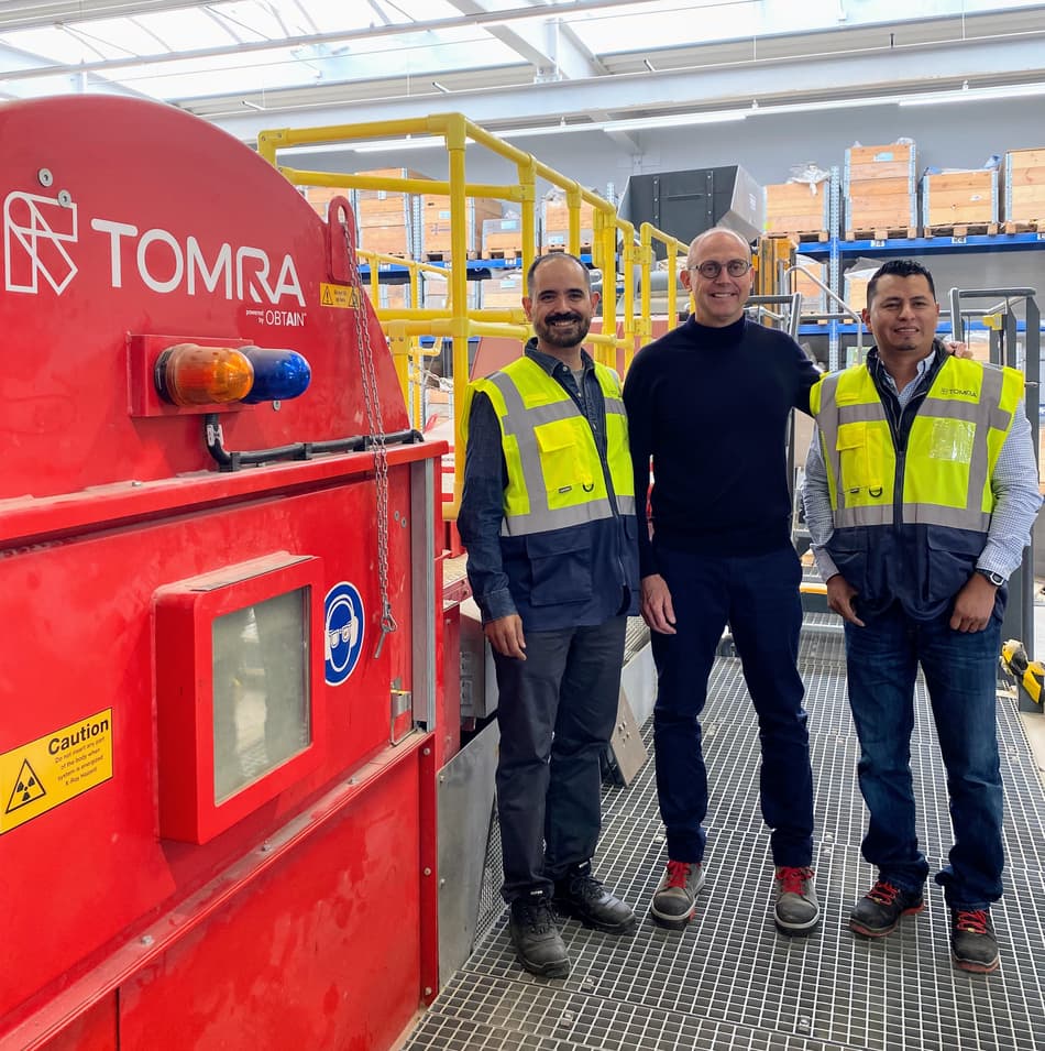 Men standing next to TOMRA Mining machine
