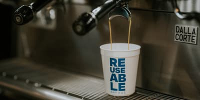 coffee being brewed into a reusable cup