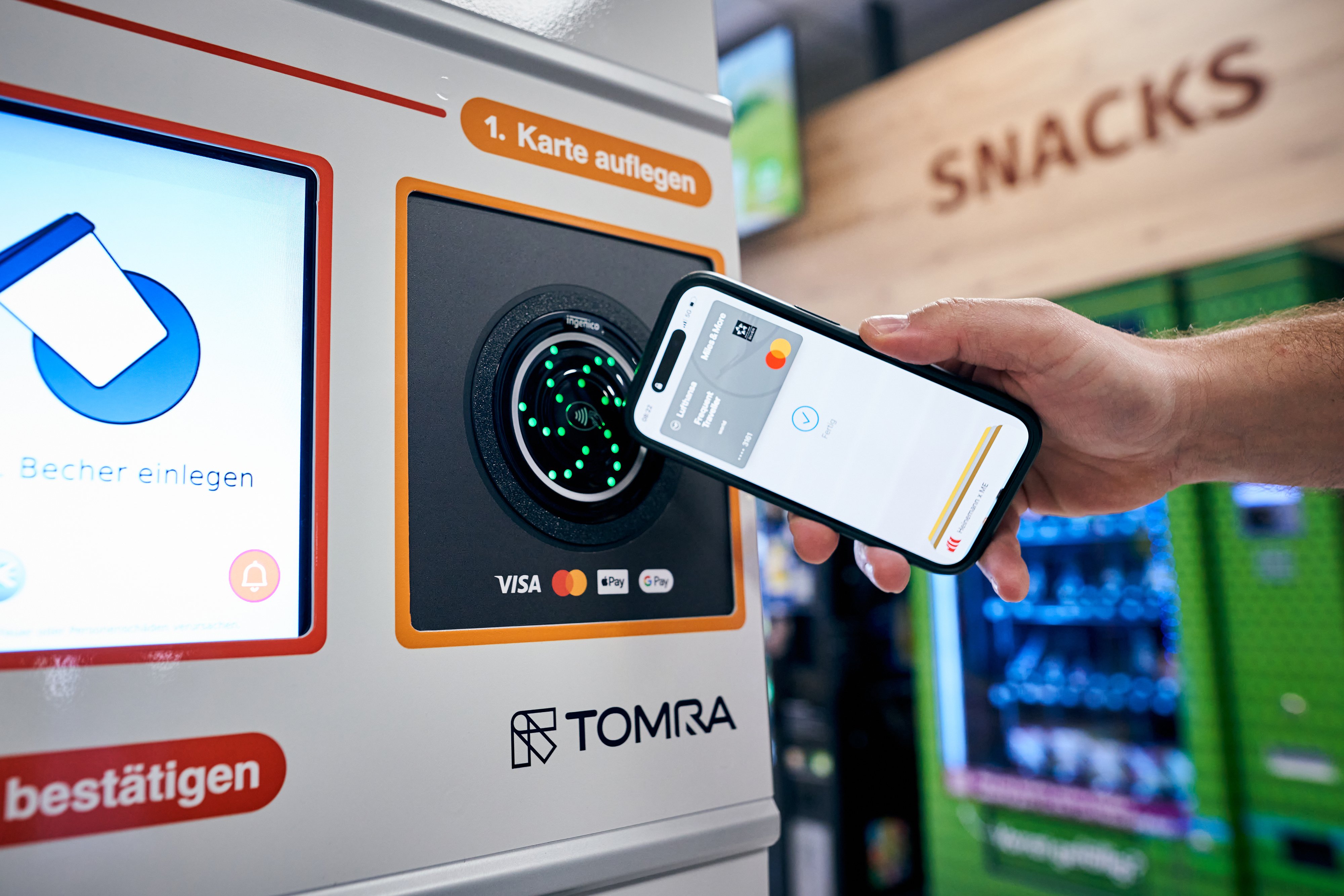 Person registering their payment credentials at a TOMRA Tap&Go reusable cup return machine in Freiburg.