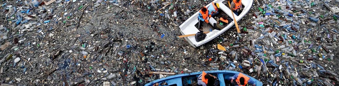 Boat floating in an ocean full of litter