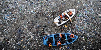 Boot treibt in einem Meer voller Müll
