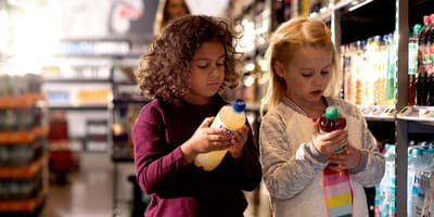 Photo de petites filles dans un magasin et regardant des bouteilles