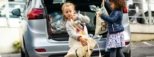 Image of kids getting containers from car boot