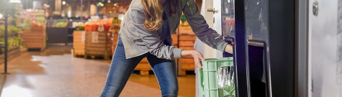 lady using t9 reverse vending machine with crates