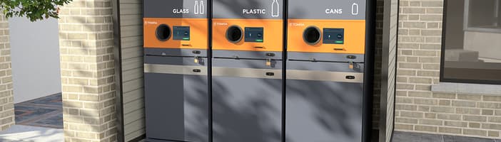 Tres máquinas de devolución de depósitos TOMRA S1 Rugged en un espacio exterior para la recogida de vidrio, plástico y latas
