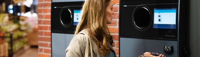 Woman using TOMRA T9 reverse vending machine