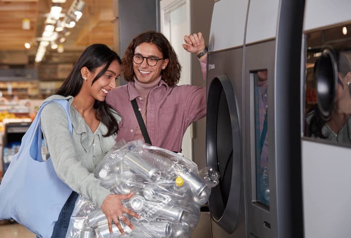 Happy consumers return their used beverage containers at a reverse vending machine