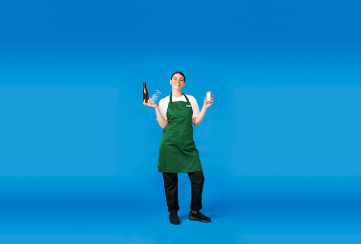 A woman in a green apron holds used beverage containers on a blue background