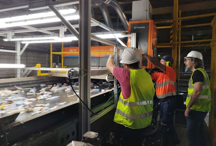 Men working on TOMRA AI Waste sorting machine