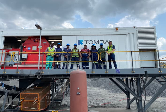 A group of people standing next to the TOMRA COM XRT 2.0 sorter