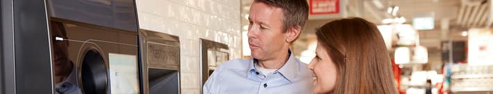 Image of retailer showing consumer how to use reverse vending machine