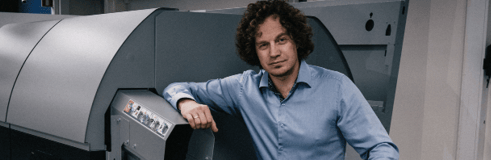 image of a man standing beside a sorting machine