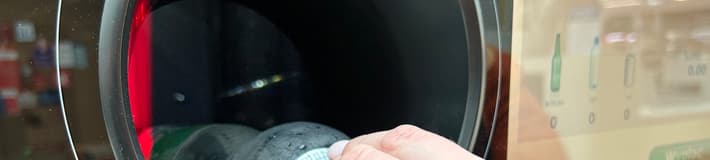 Person inserting plastic bottle into a reverse vending machine