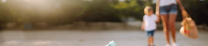 Family picking up bottle litter on beach