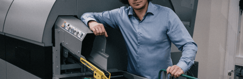 image of a man standing beside a sorting machine