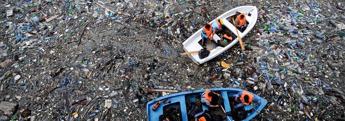 Barco flotando en un océano lleno de basura