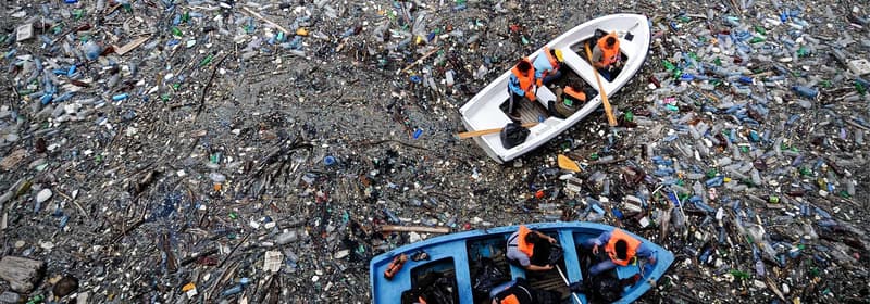 Boot treibt in einem Meer voller Müll