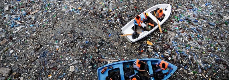 Barco flotando en un océano lleno de basura