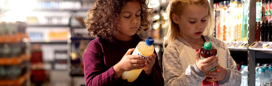 Photo de petites filles dans un magasin et regardant des bouteilles