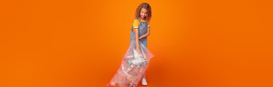 Retrato de una chica sosteniendo una bolsa llena de envases sobre un fondo naranja